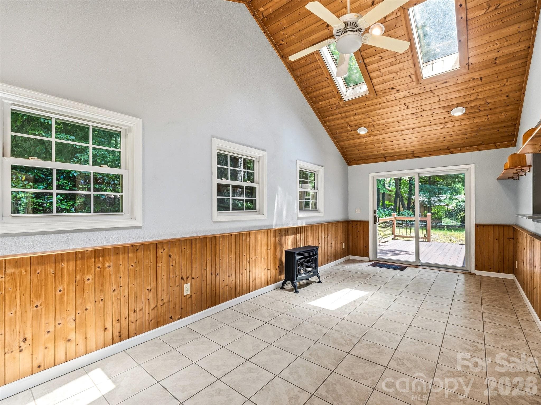 Sunroom looks out onto deck and level backyard - 206 Camellia Way, Laurel Park