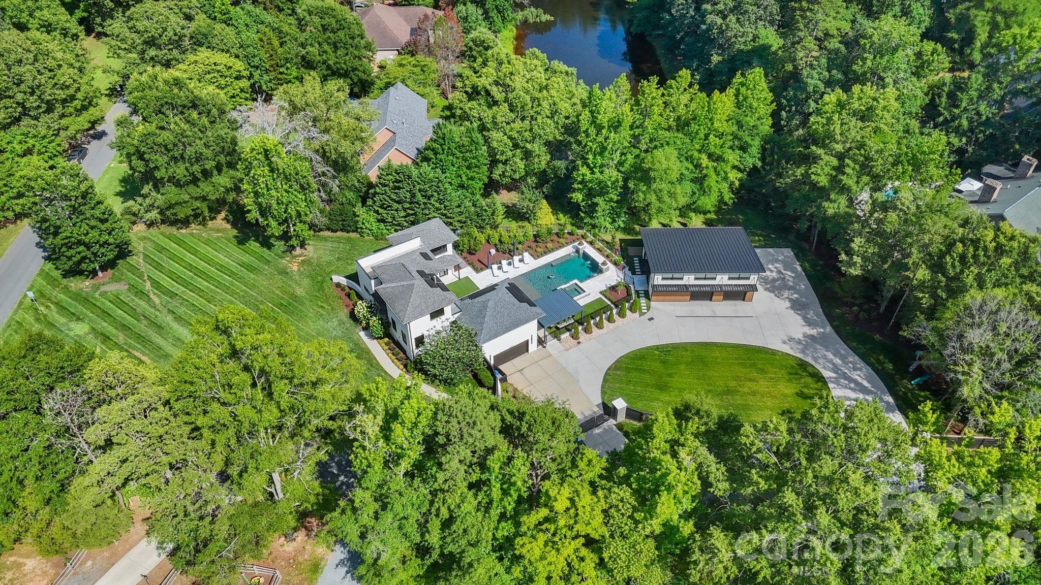 Aerial view of luxury 1.58-acre estate property with private gated grounds and mature landscaping - 1064 Greylyn Drive, Matthews