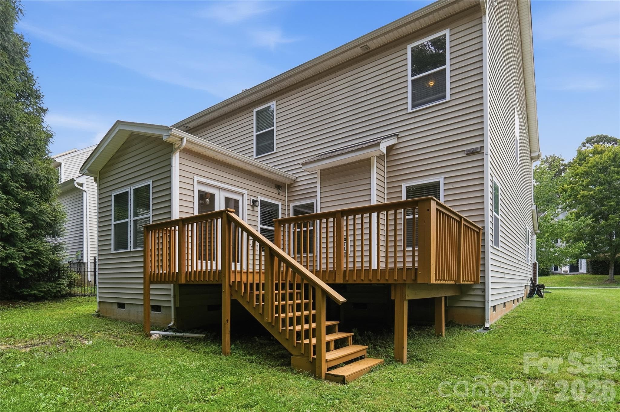 Rear exterior with a spacious deck overlooking the yard - Indian Trail