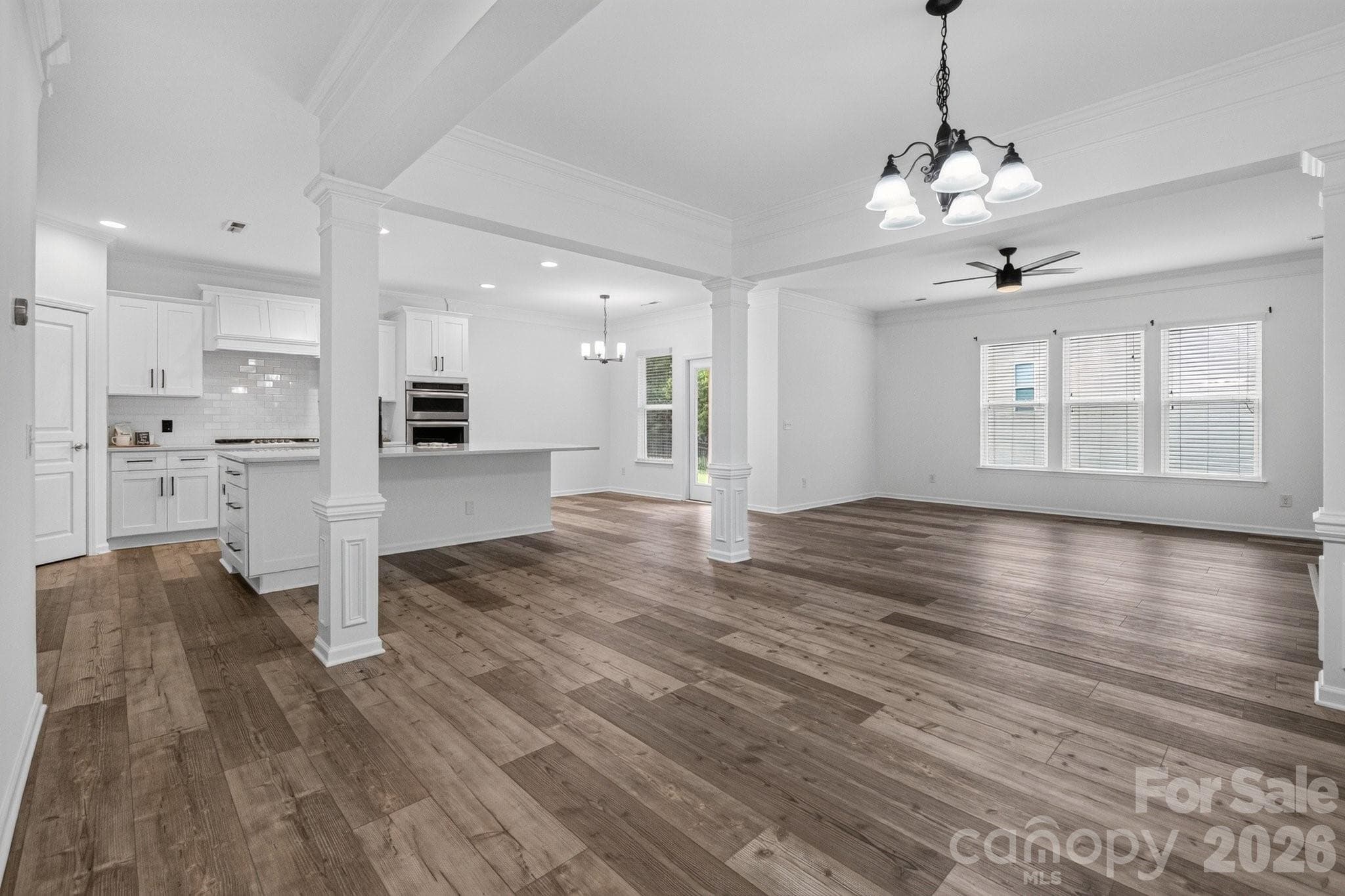Your open concept view of the dining room, family room and kitchen with stunning LVP flooring (2021) through out. - Charlotte