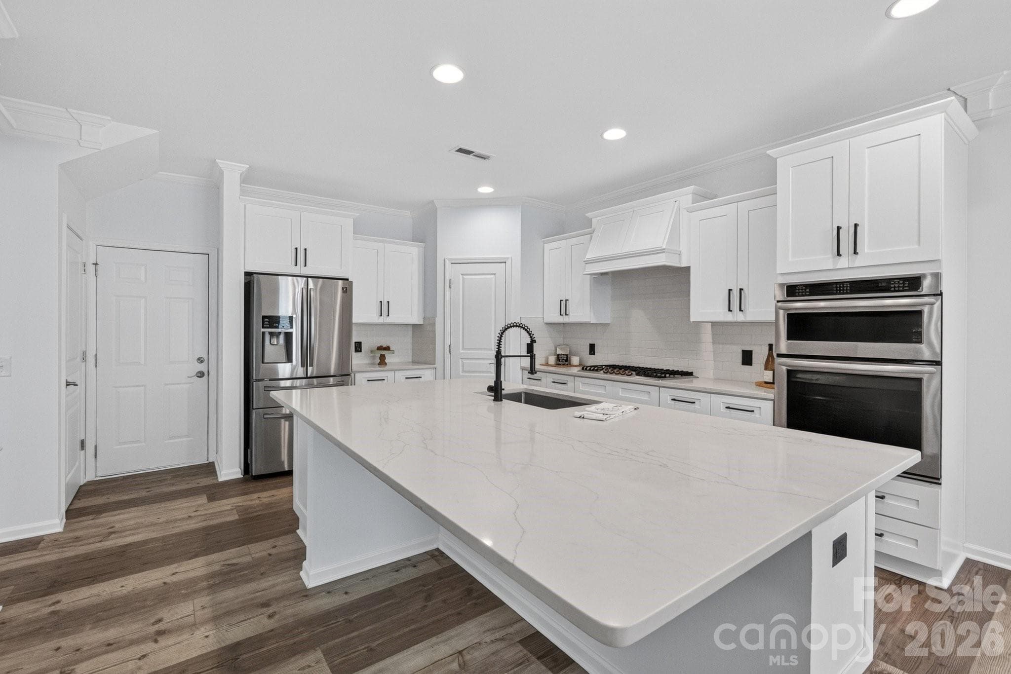 Quartz counter tops adorn this 9ft plus island which is perfect for additional seating as well as preparing meals. The dishwasher is also conveniently located next to the sink in the island. - Charlotte
