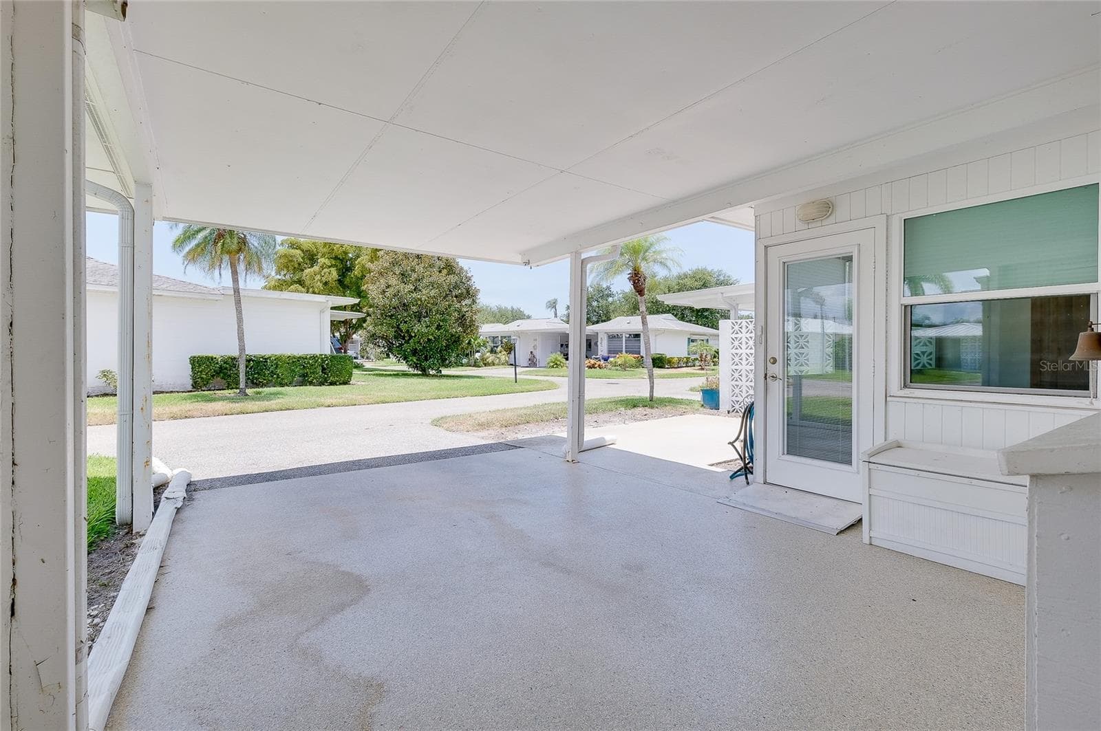 Carport with door to Florida room and showing proximity to patio. - 112 THE CORSO #112, VENICE