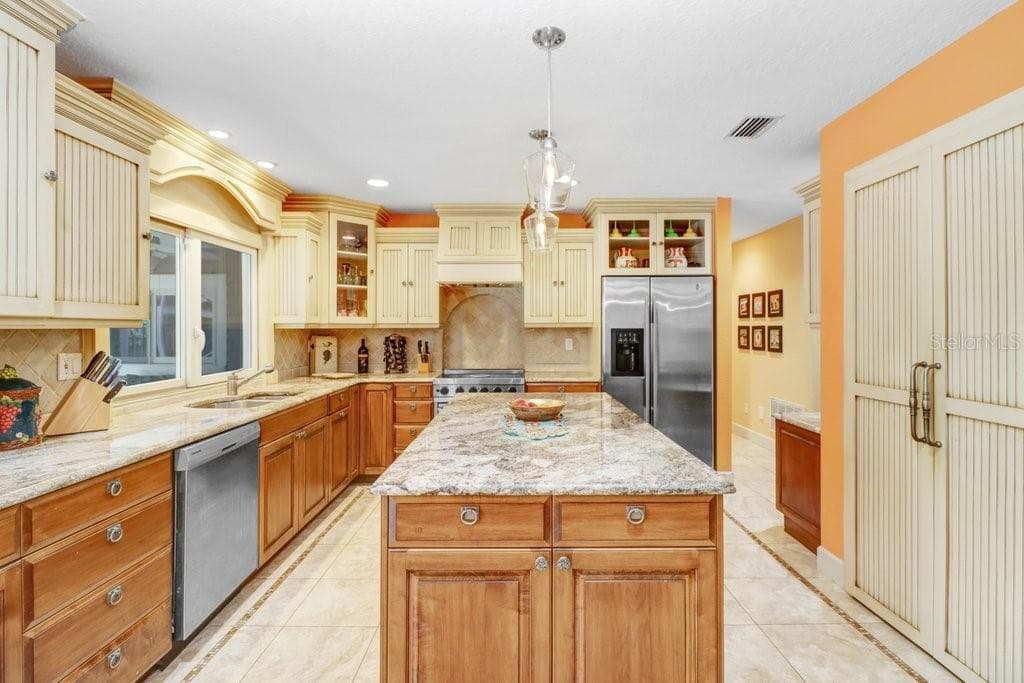 Beautiful glazed custom cabinets with granite counter tops walk in pantry , Stainless steel appliances which includes a Viking Range. - 1976 DUNLOE CIR, DUNEDIN
