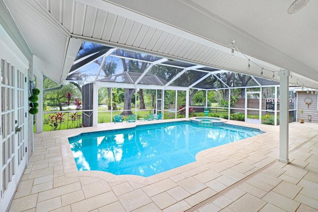 1992 square foot pool/spa/patio area custom pavers and tropical serene views of backyard to lake area. - 1976 DUNLOE CIR, DUNEDIN