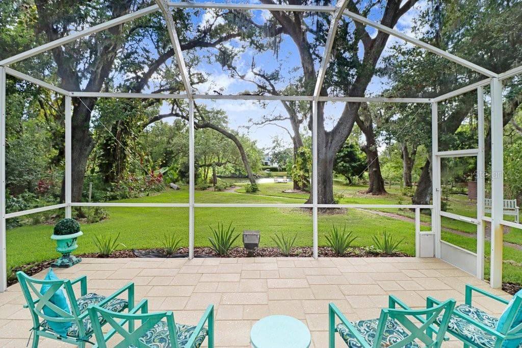Another view of the step-down patio with backyard mature oaks and walking path to lake area. - 1976 DUNLOE CIR, DUNEDIN