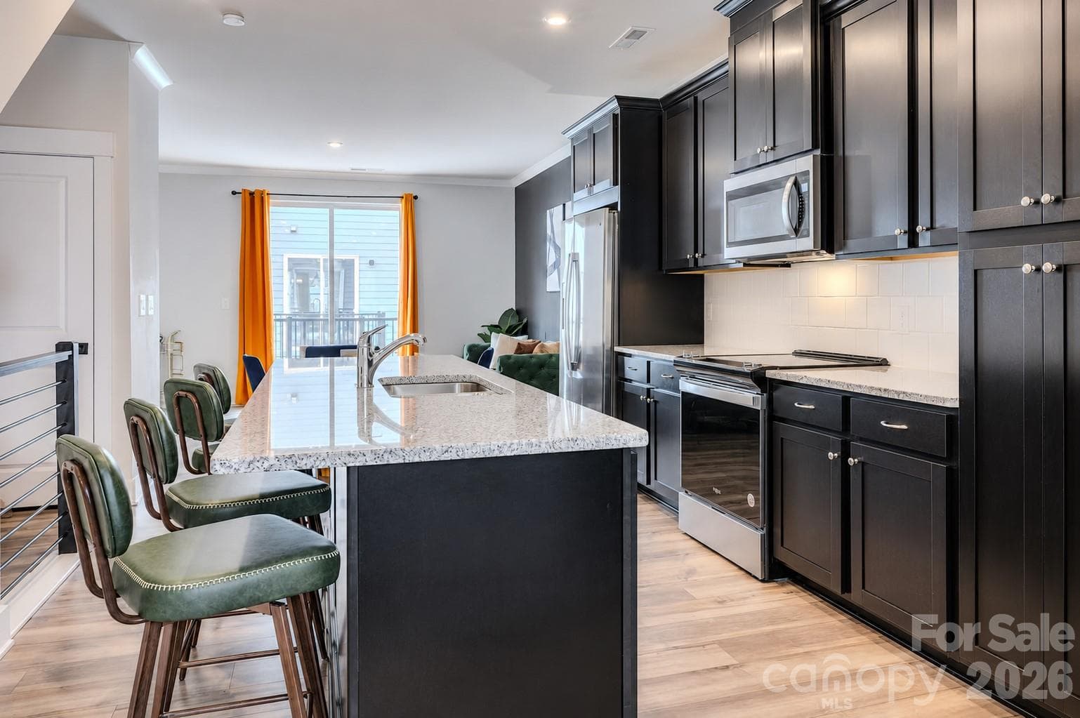 The modern kitchen showcases stainless steel appliances, abundant cabinetry, sleek quartz countertops, a subway tile backsplash, and ample prep space, creating the perfect blend of style and functionality. - 3019 Jolene Court, Charlotte