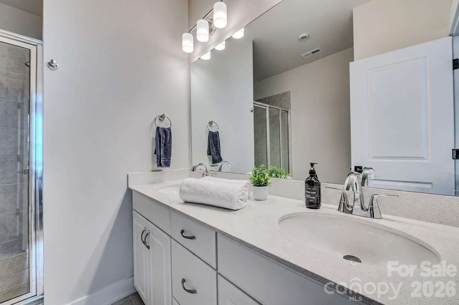 The spacious primary bathroom features a dual-sink vanity with ample counter space, modern finishes, and a large walk-in shower, creating a bright and relaxing retreat. - 3019 Jolene Court, Charlotte