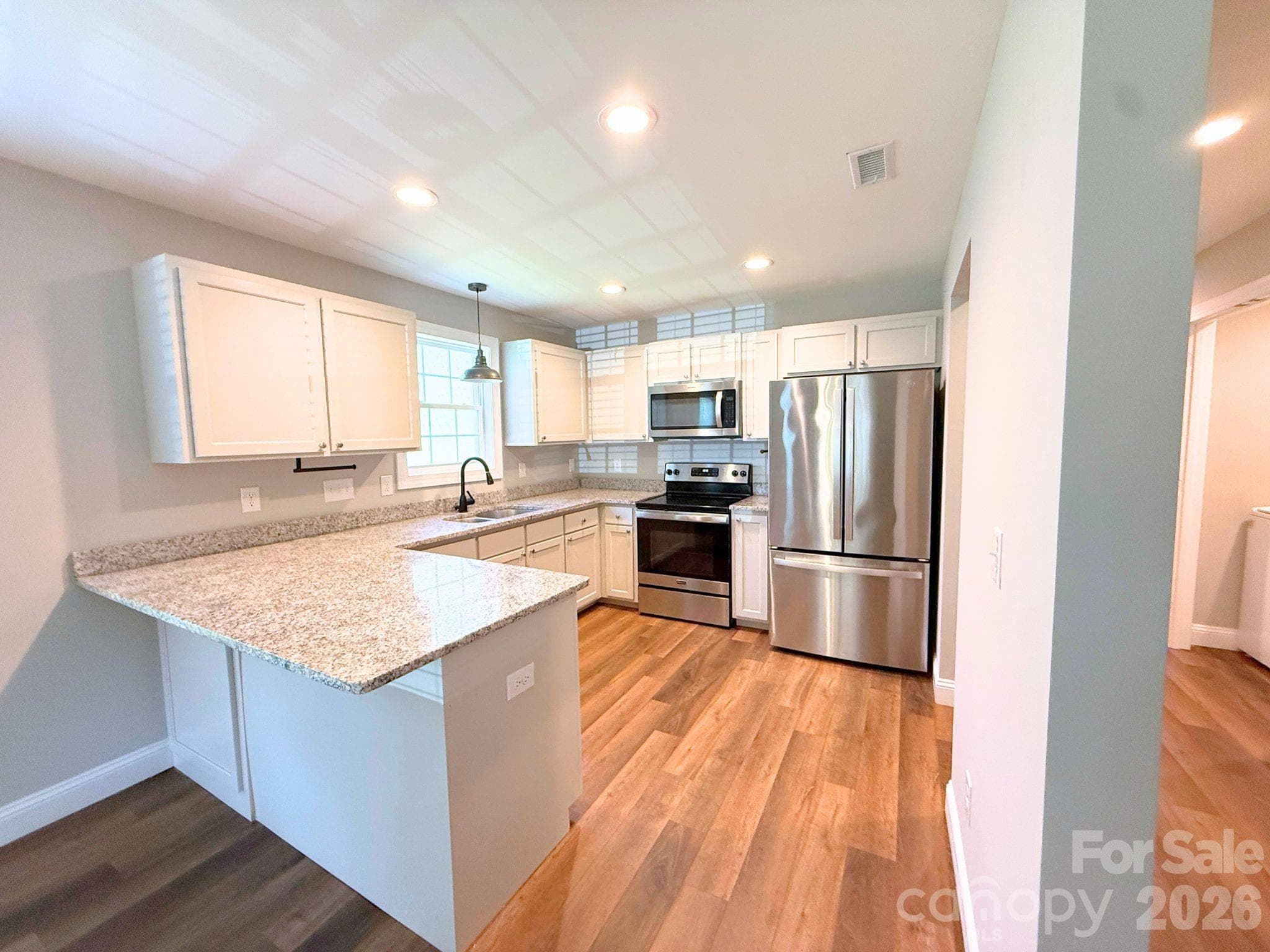 Kitchen – Stylish kitchen with granite countertops, white shaker cabinetry, stainless steel appliances, recessed lighting, and a functional peninsula for additional prep and seating space. - Chester