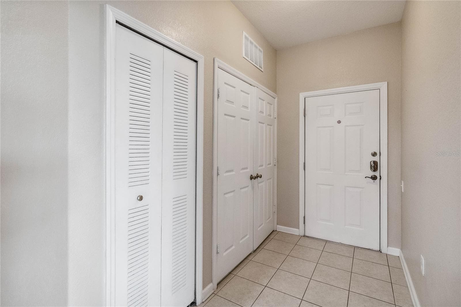 Entrance hallway showing laundry closet on the left. - 2821 E ALMATON LOOP #401, KISSIMMEE