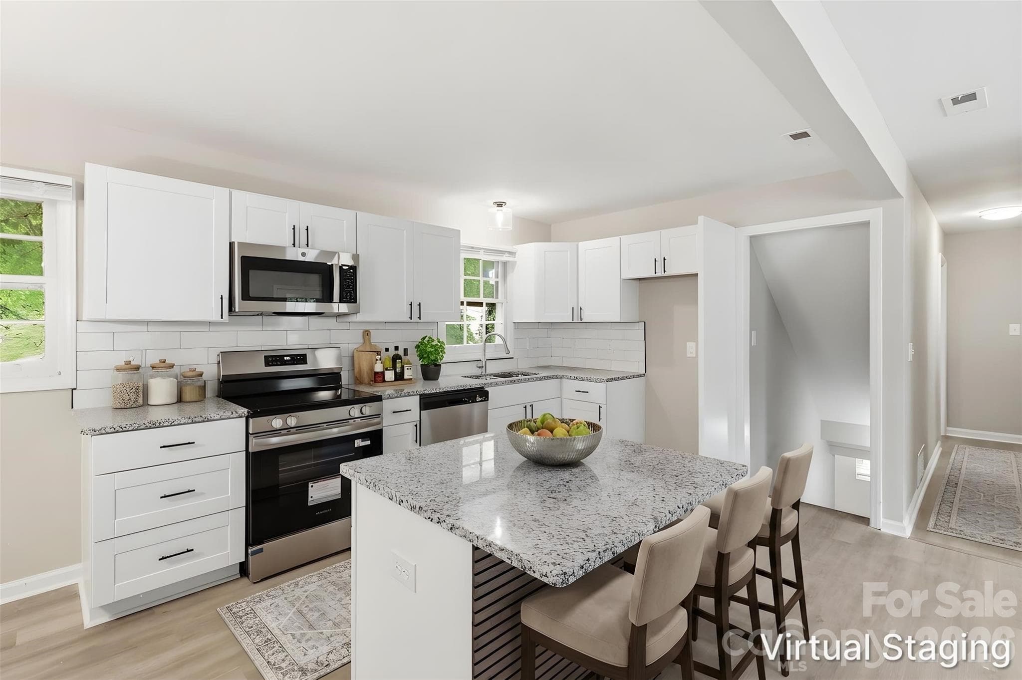 Your upgraded kitchen serves as the "heart of the home" due to the updates and well-designed layout, integrating it with the living room & dining areas. Highlights include new kitchen island, granite counters, conveying SS appliances (dishwasher, electric range & microwave), SS dual deep sink, and wraparound subway tile backsplash (virtually staged & enhanced). - Charlotte