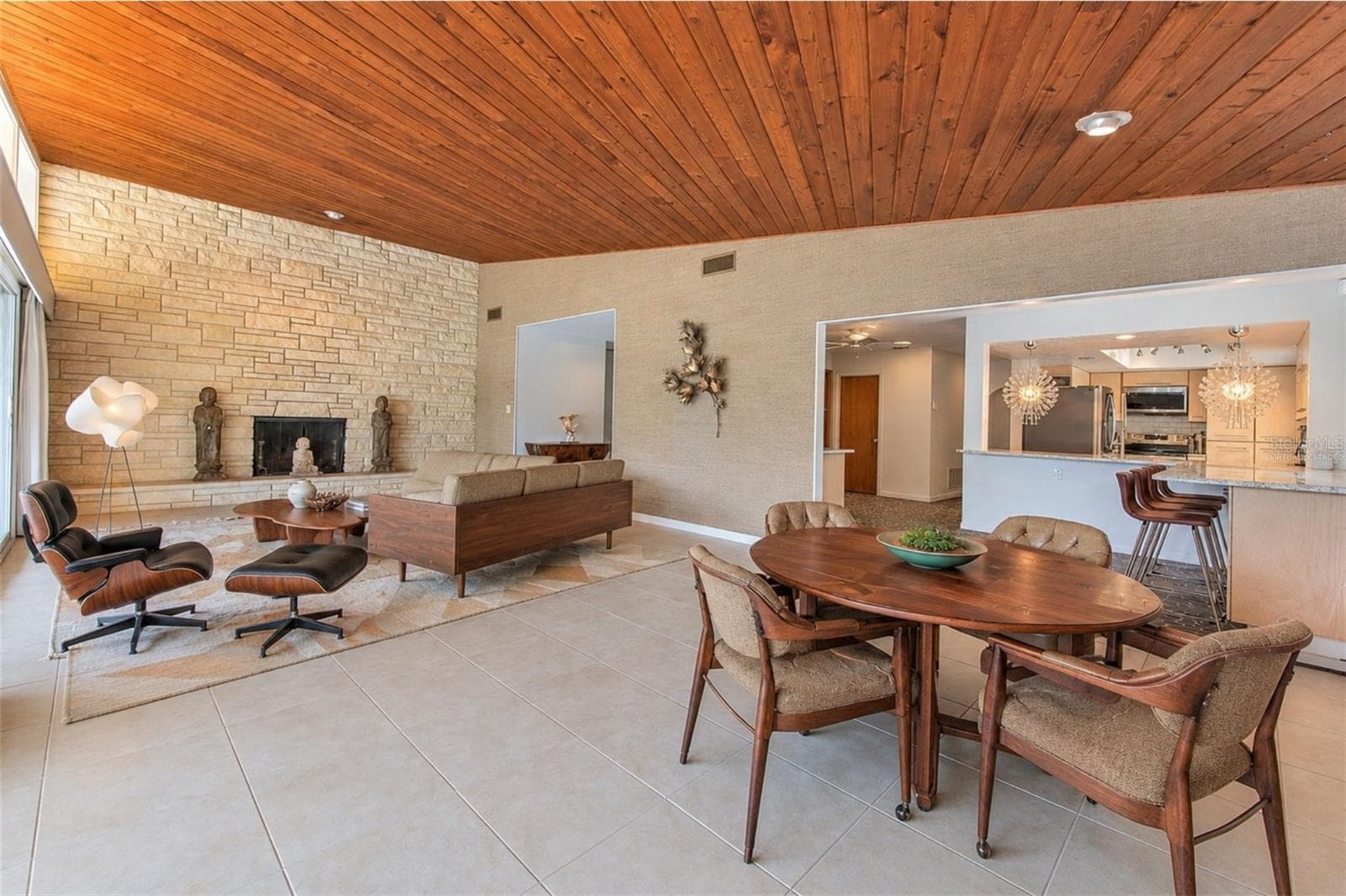 virtually staged -  Waterfront MCM living room, floor to ceiling glass slider doors, stone fireplace, tongue & groove ceiling - 7102 MANDY LN, NEW PORT RICHEY