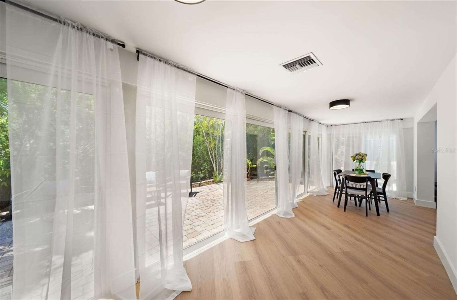 Sliders that lead out onto the private paver patio for the perfect indoor-outdoor living experience - 578 SPANISH DR S, LONGBOAT KEY