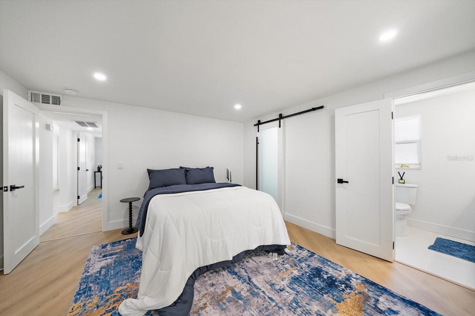 Primary bedroom with solid wood door and solid wood bard doors, walk-in closet and ensuite bathroom - 578 SPANISH DR S, LONGBOAT KEY