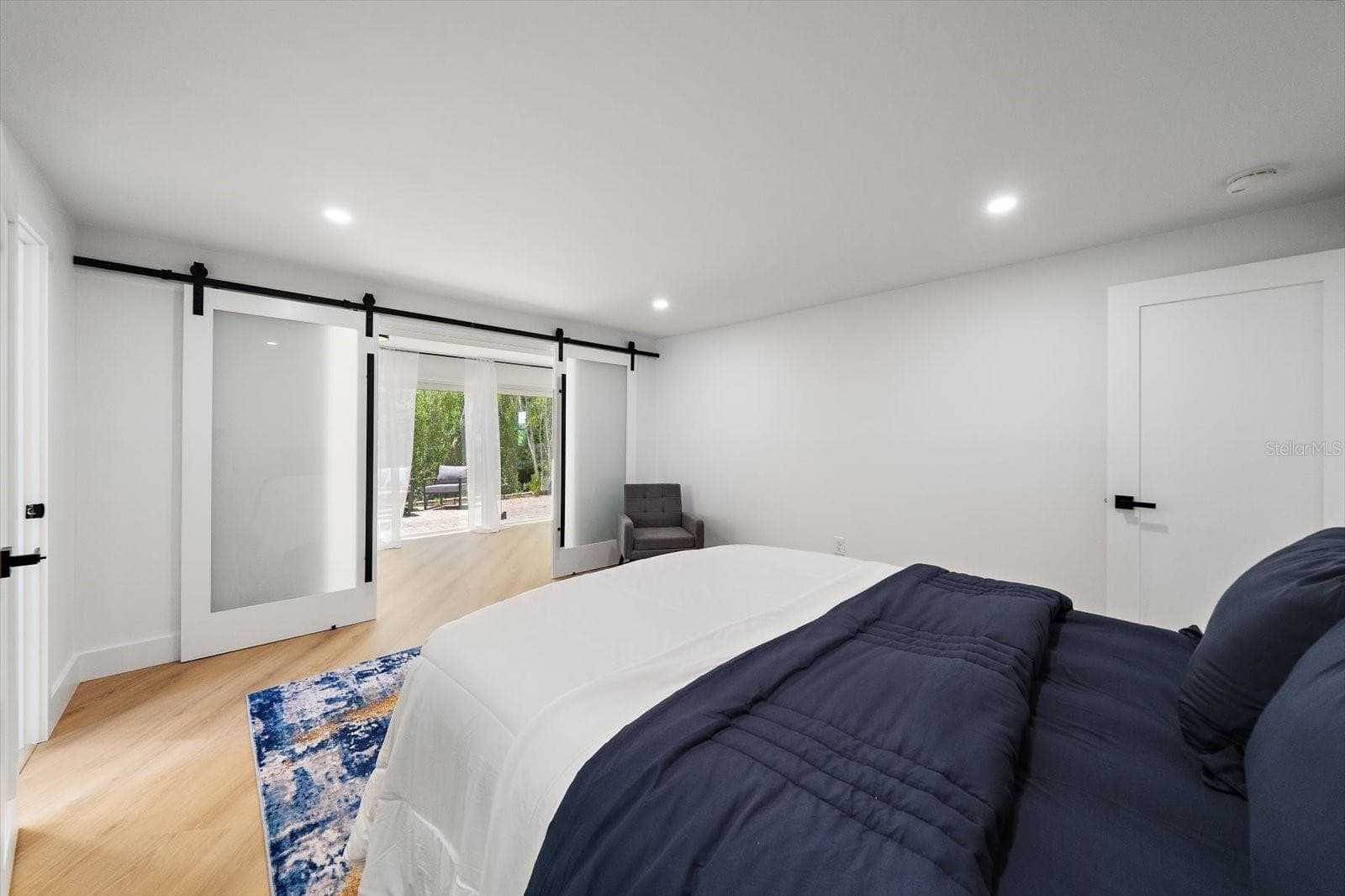 Primary bedroom with solid barn doors to the additional Florida room space - 578 SPANISH DR S, LONGBOAT KEY