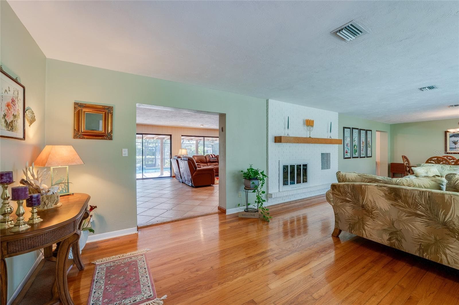 View from kitchen to family room with double-sided fireplace - 697 JOHN ANDERSON DR, ORMOND BEACH