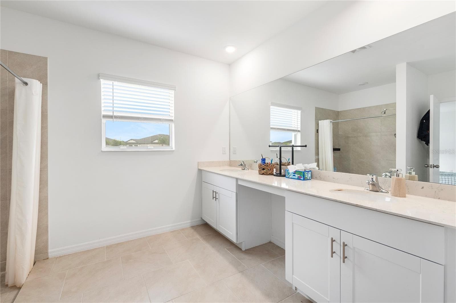 Luxurious primary bathroom with dual vanities, walk-in shower, and modern finishes. - 17177 MONTE ISOLA WAY, NORTH FORT MYERS