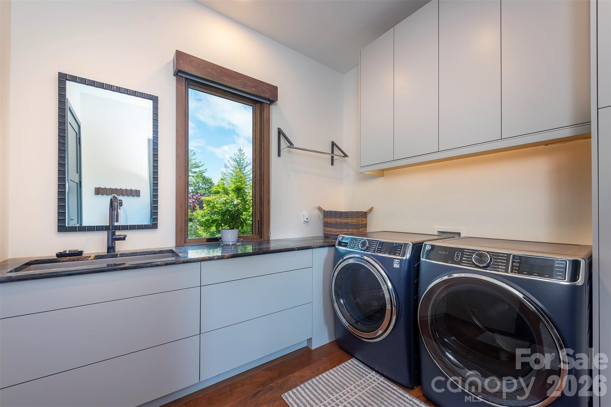 Laundry room just off garage entrance with sink and amazing storage space - Asheville
