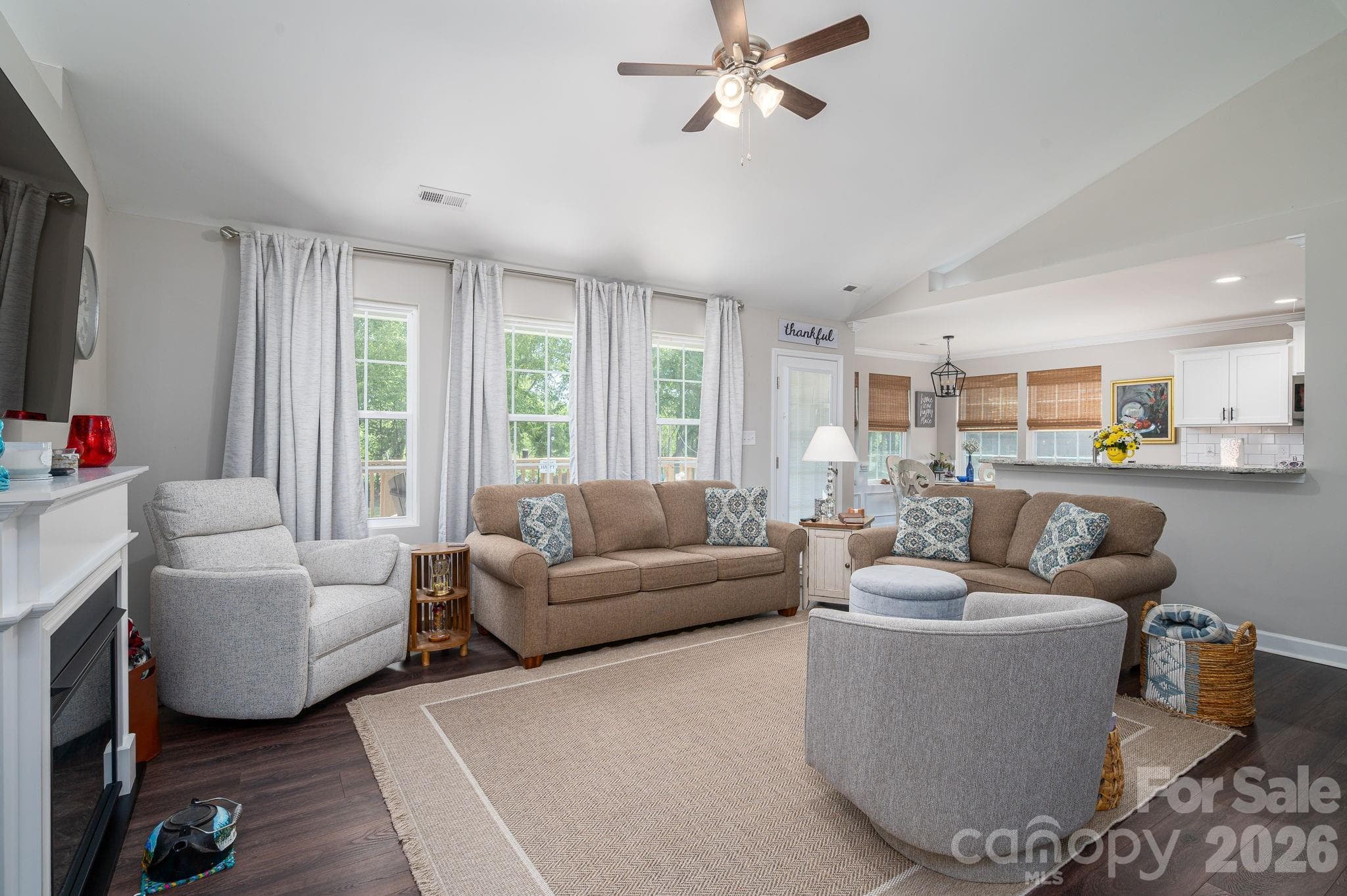 The open floor plan, vaulted ceiling and a lot of windows create an attractive and spacious living area. - Newton
