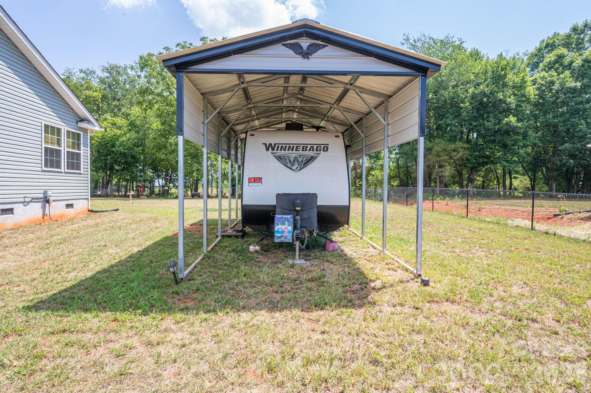 Metal RV/Boat Carport sits behind double gated fence - Newton