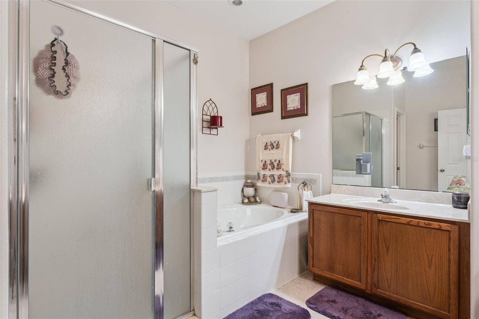 Primary bathroom features a walk in shower & spa like tub - 9955 MEDALLION BLUFF LN, ORLANDO