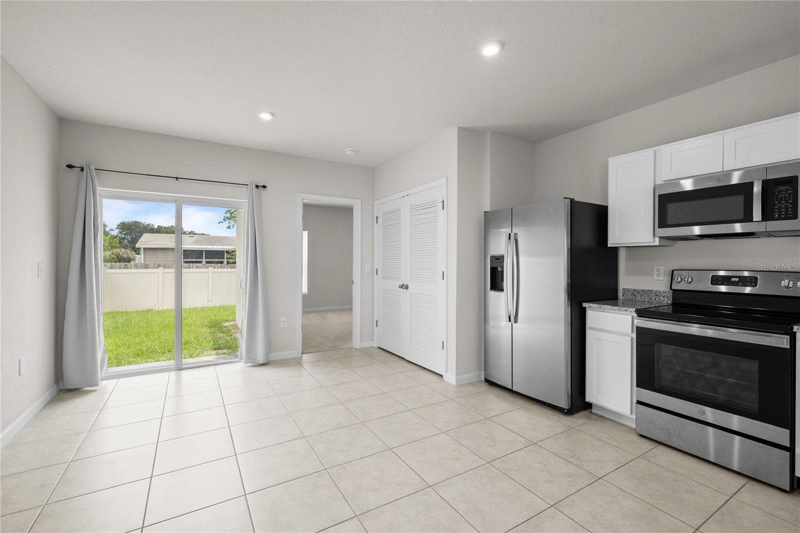 Sliders off the kitchen lead to a fenced in back yard - 35155 JOMAR AVE, ZEPHYRHILLS