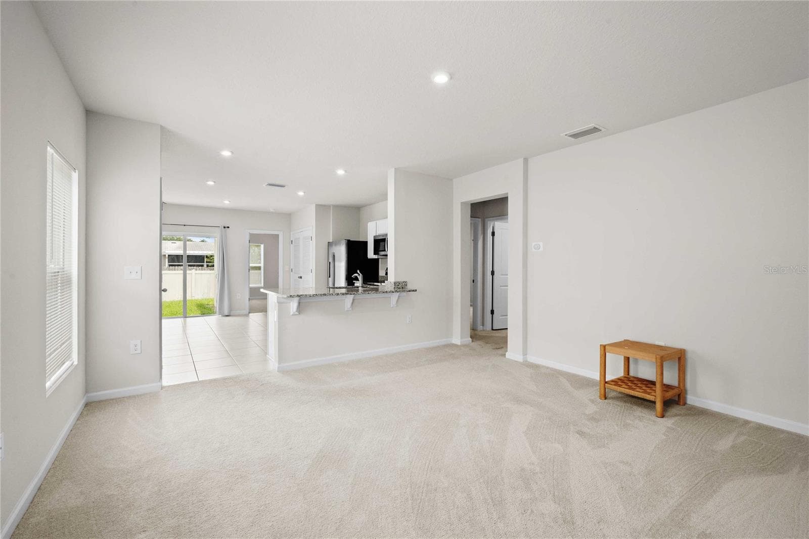 The living room is just off the kitchen - 35155 JOMAR AVE, ZEPHYRHILLS