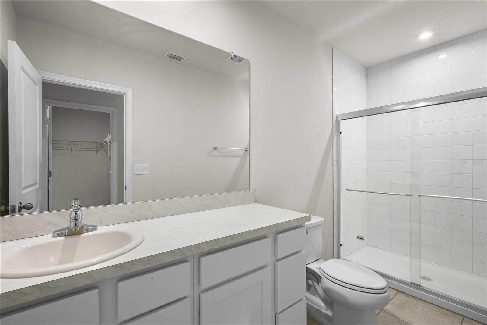 The primary bath with tiled floors and shower surround has new glass doors - 35155 JOMAR AVE, ZEPHYRHILLS