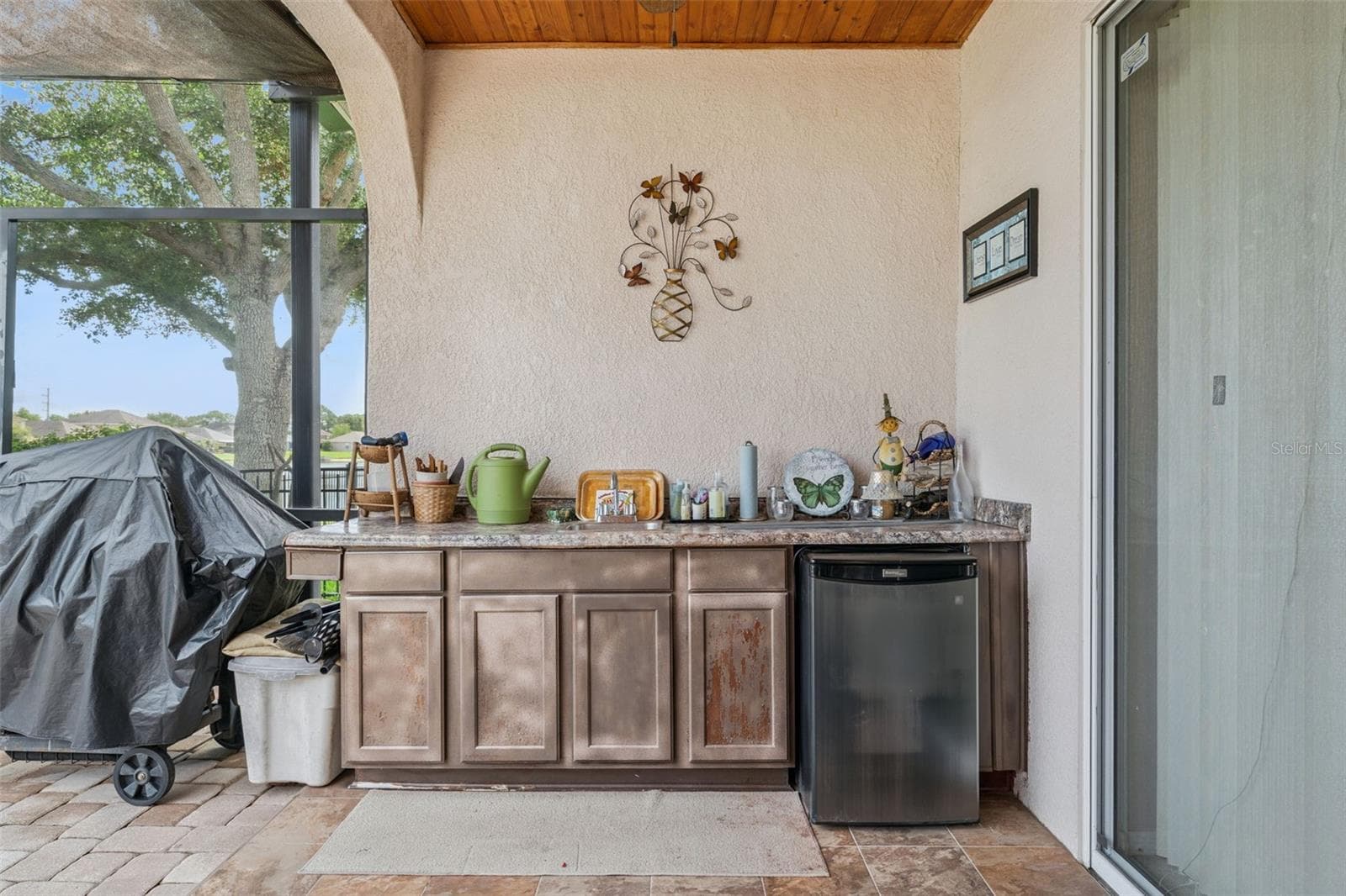 Patio equipped with an outdoor sink, built in countertop and mini refrigerator - 9955 MEDALLION BLUFF LN, ORLANDO