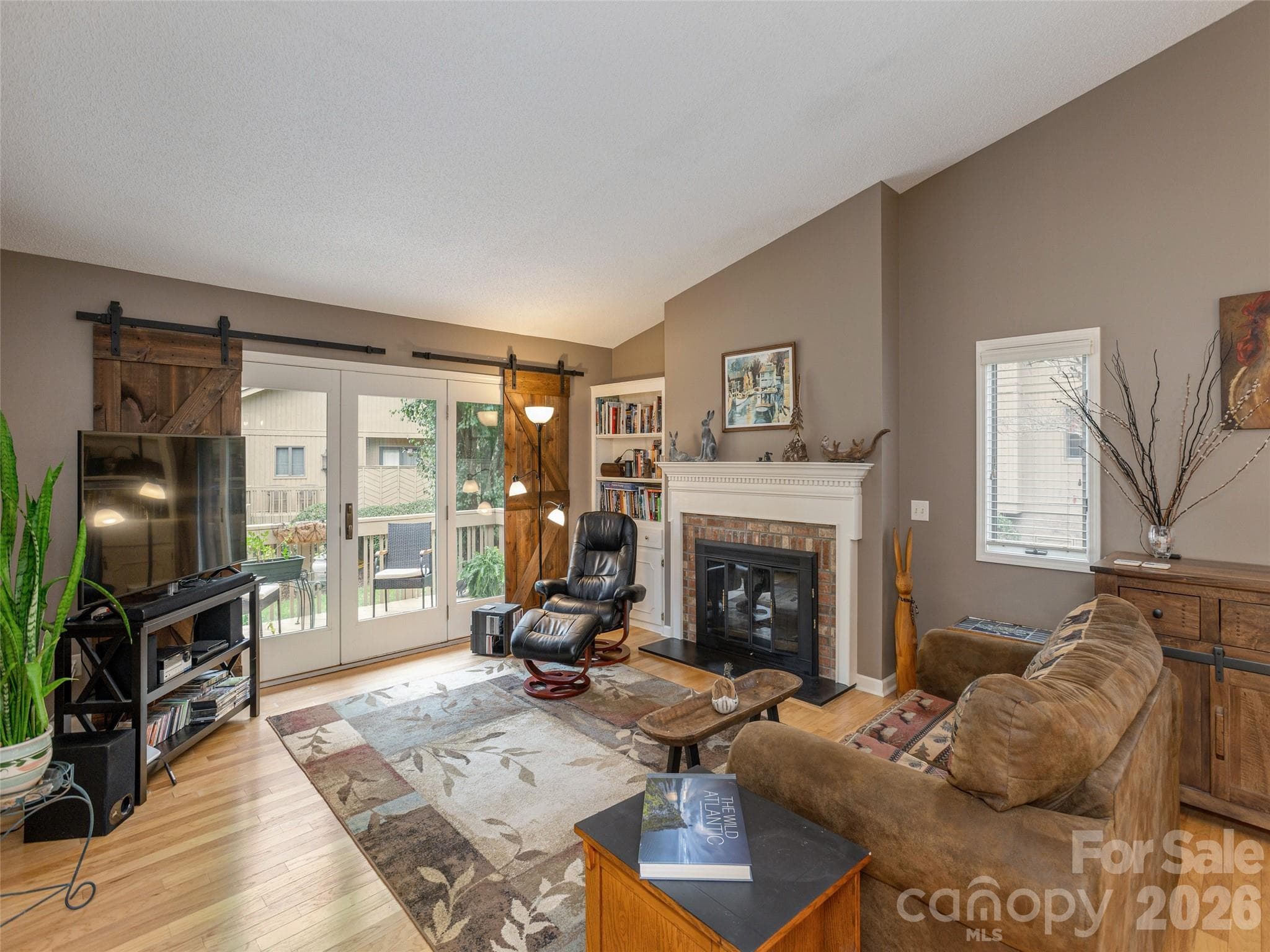 Living room is open concept with gas logs and french doors open to the back porch - 606 Red Oak Drive, Hendersonville