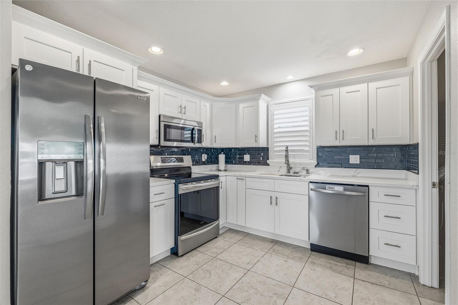 Well appointed kitchen features Quartz countertops, new stainless-steel appliance package (refrigerator, dishwasher, range & microwave), deep basin sink, with soft close drawers, cabinets and recessed lighting. - 4320 FLORAMAR TER, NEW PORT RICHEY