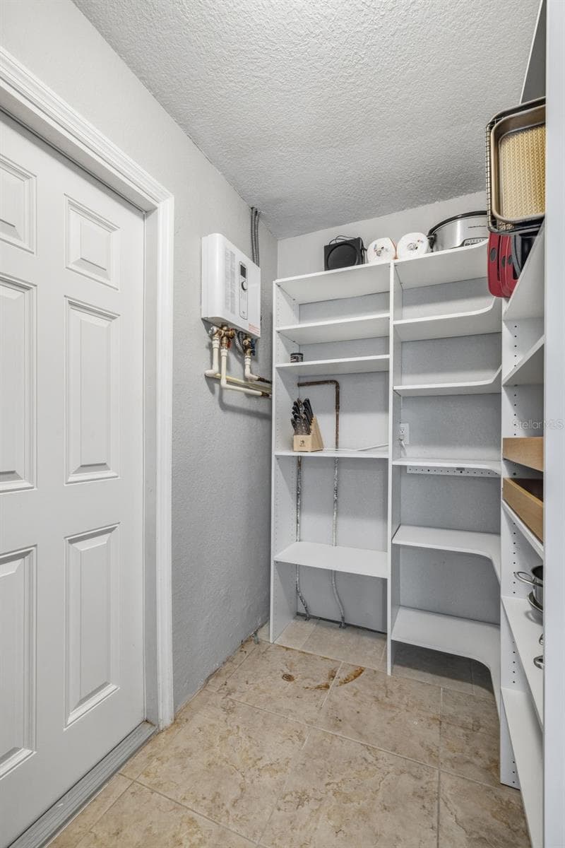 Utility room / Pantry / Storage / Laundry room - Home features a Tankless Water Heater as well as a whole home water softener. - 4320 FLORAMAR TER, NEW PORT RICHEY