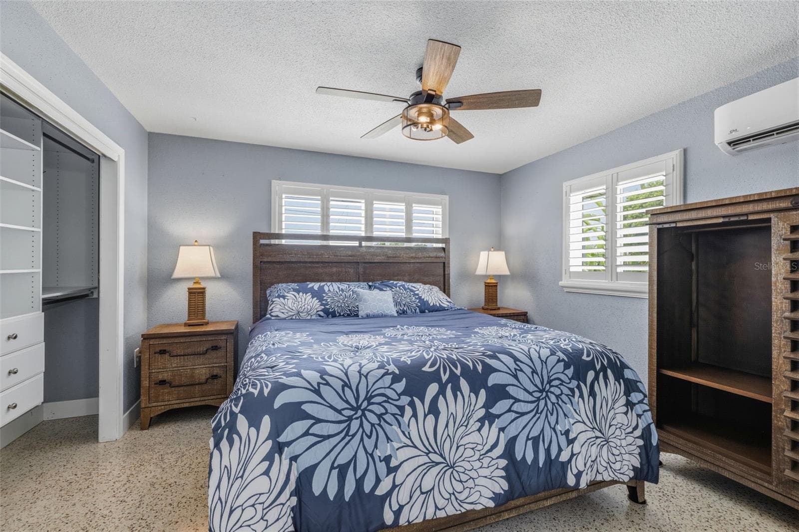 Primary Bedroom with polished Terrazzo flooring, custom ceiling fan, mini-split HVAC system, plantation shutters and custom closet organizer. - 4320 FLORAMAR TER, NEW PORT RICHEY