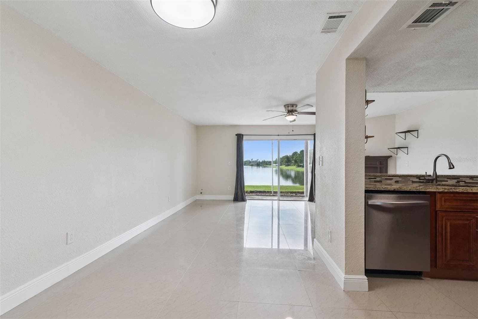 View from Entryway to dining room/kitchen and living room - 214 MAJORS LN #C, KISSIMMEE