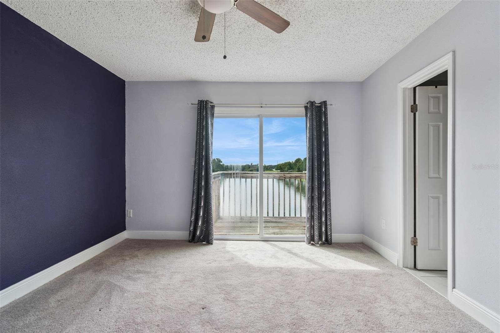 Primary Bedroom with view to the Balcony that overlooks the pond - 214 MAJORS LN #C, KISSIMMEE