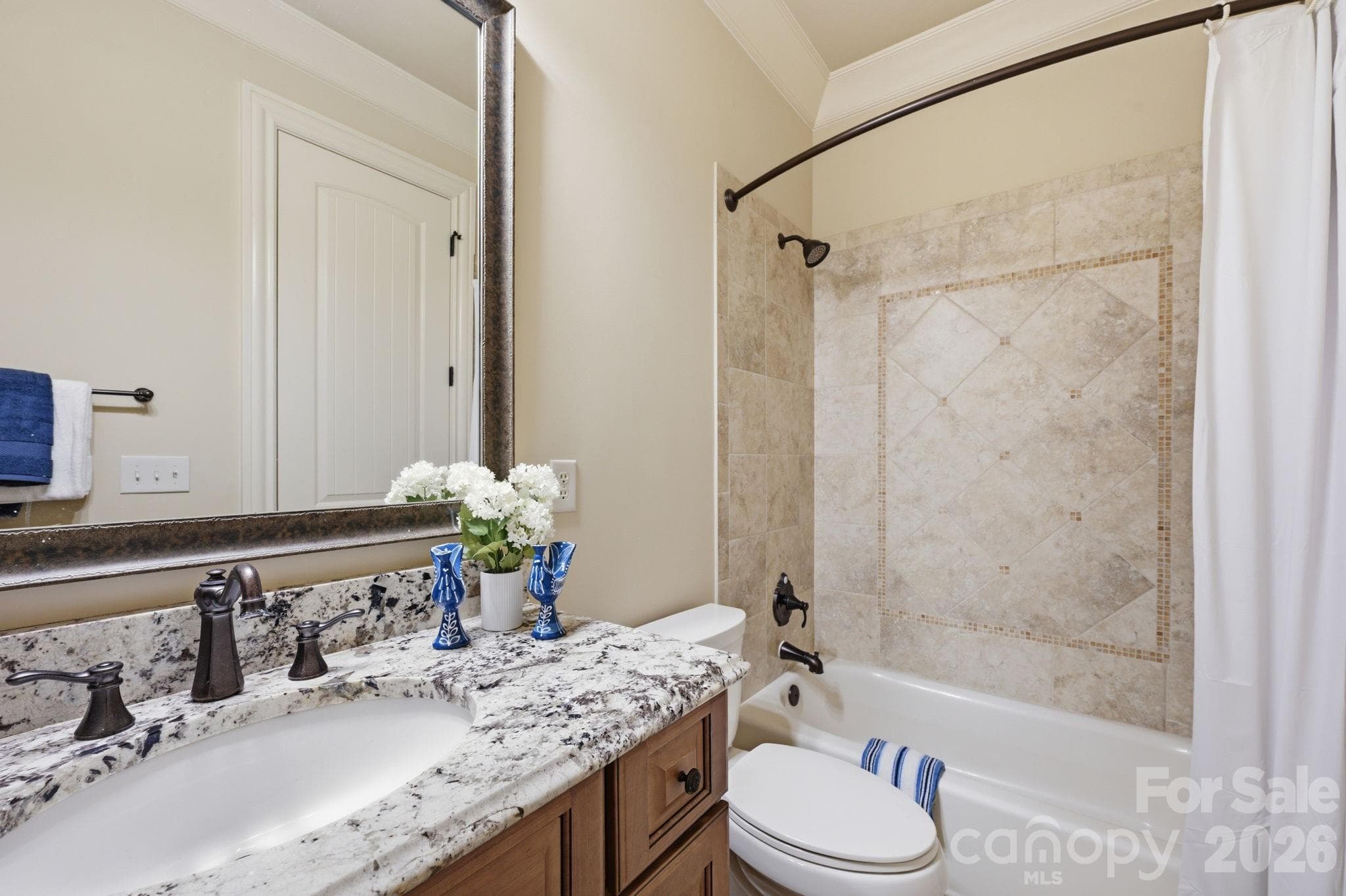 Guest suite 2 has a decorative tile surround tub/shower combo - 8528 Waxhaw Creek Road, Waxhaw