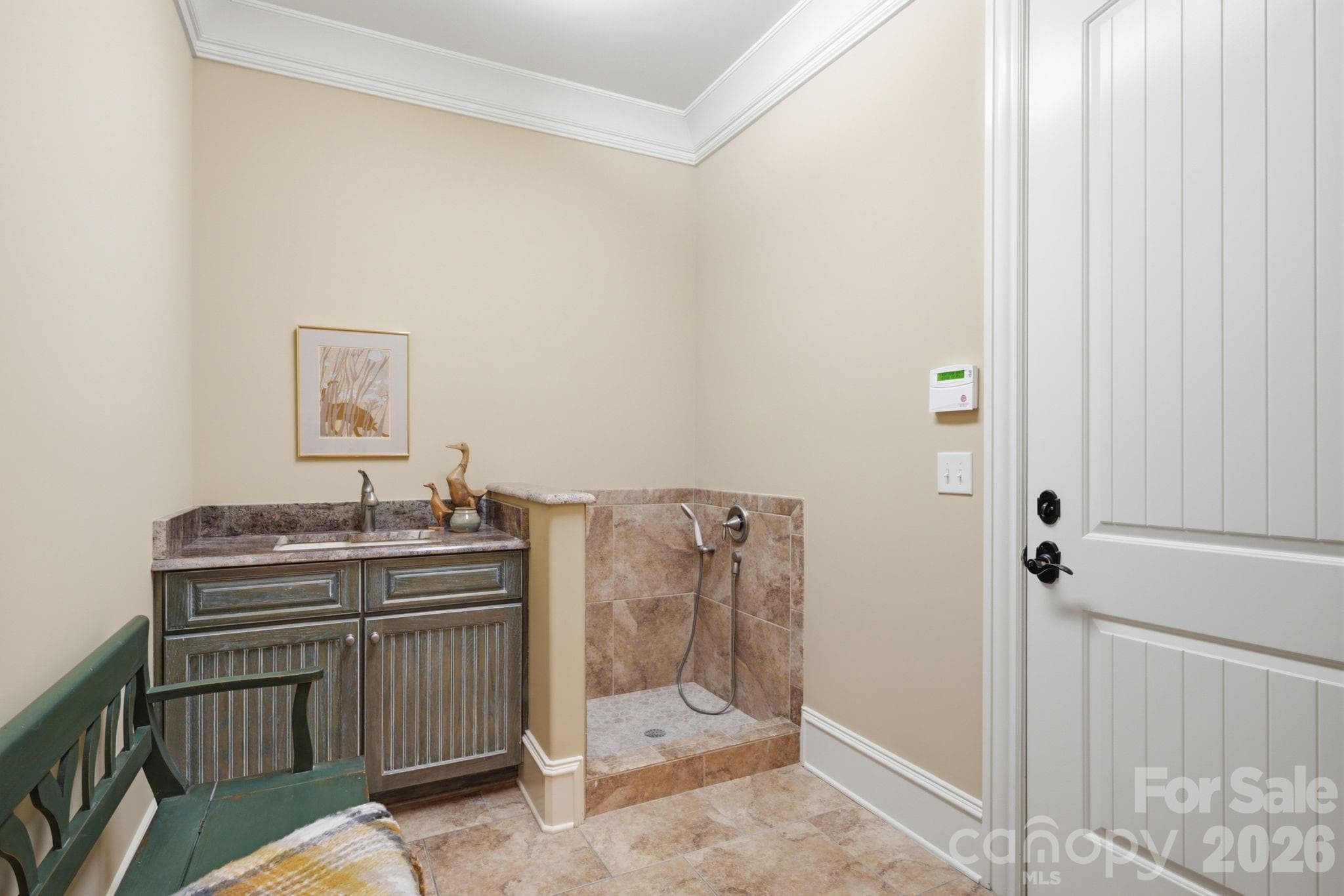 Mud room with cabinet and sink.  Dog shower or muddy boot bath off lower level oversized garage - 8528 Waxhaw Creek Road, Waxhaw