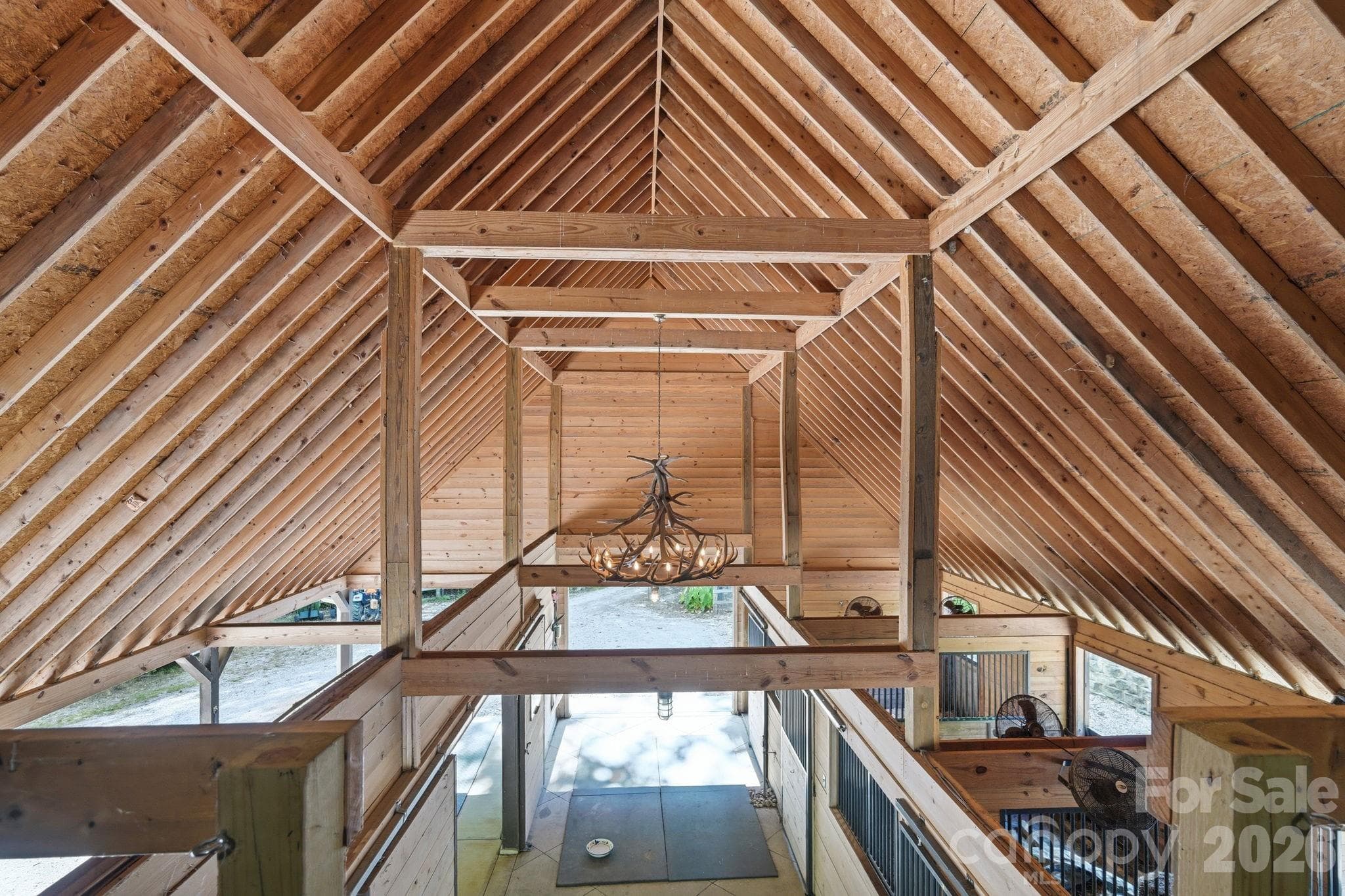 Antler chandelier, stalls have exterior dutch doors, mats and fans - 8528 Waxhaw Creek Road, Waxhaw