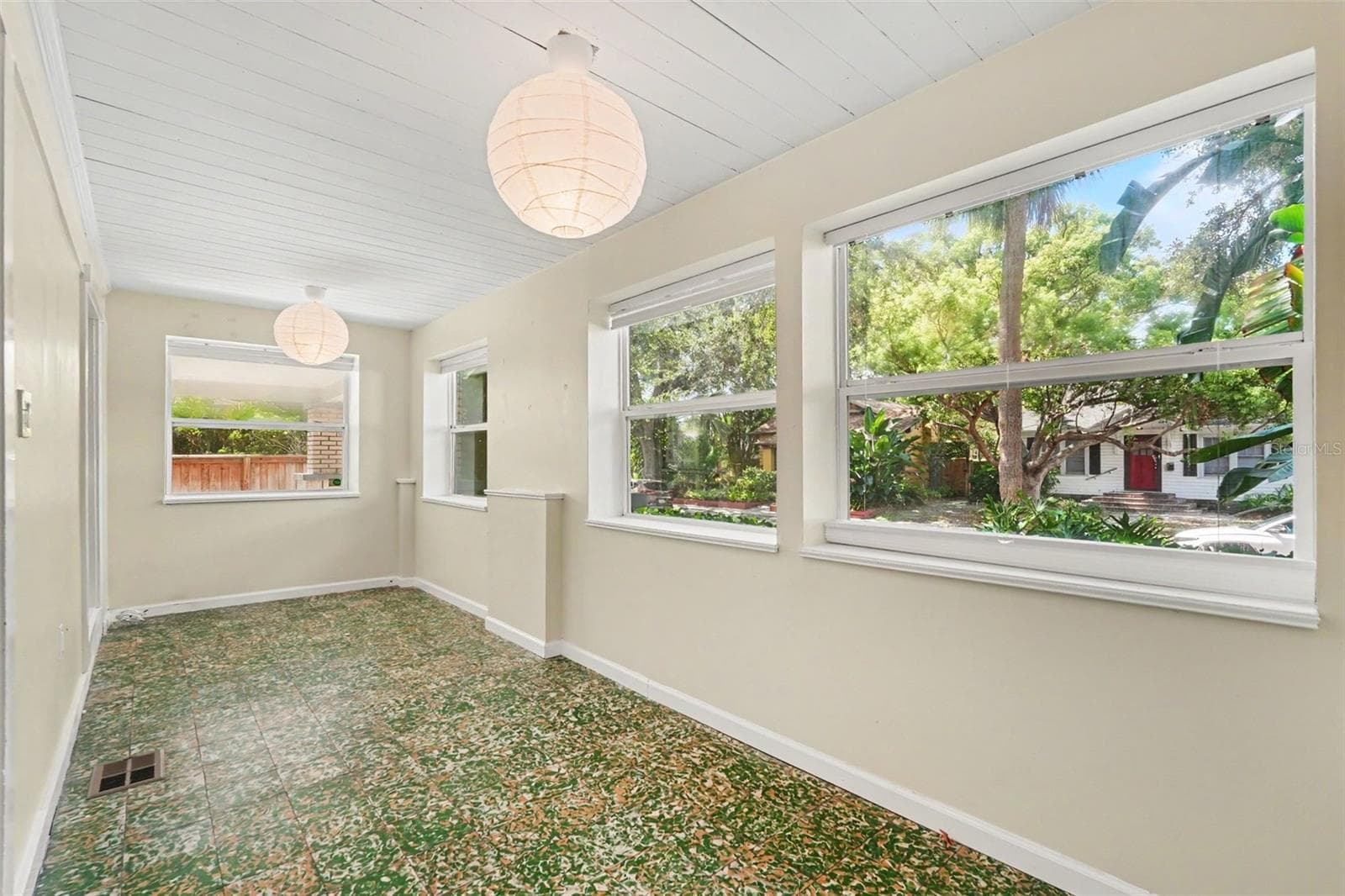 One of the home’s most distinctive spaces, the enclosed front porch features original Cuban tile and endless possibilities for relaxing, reading, or entertaining. - 857 21ST AVE N, ST PETERSBURG