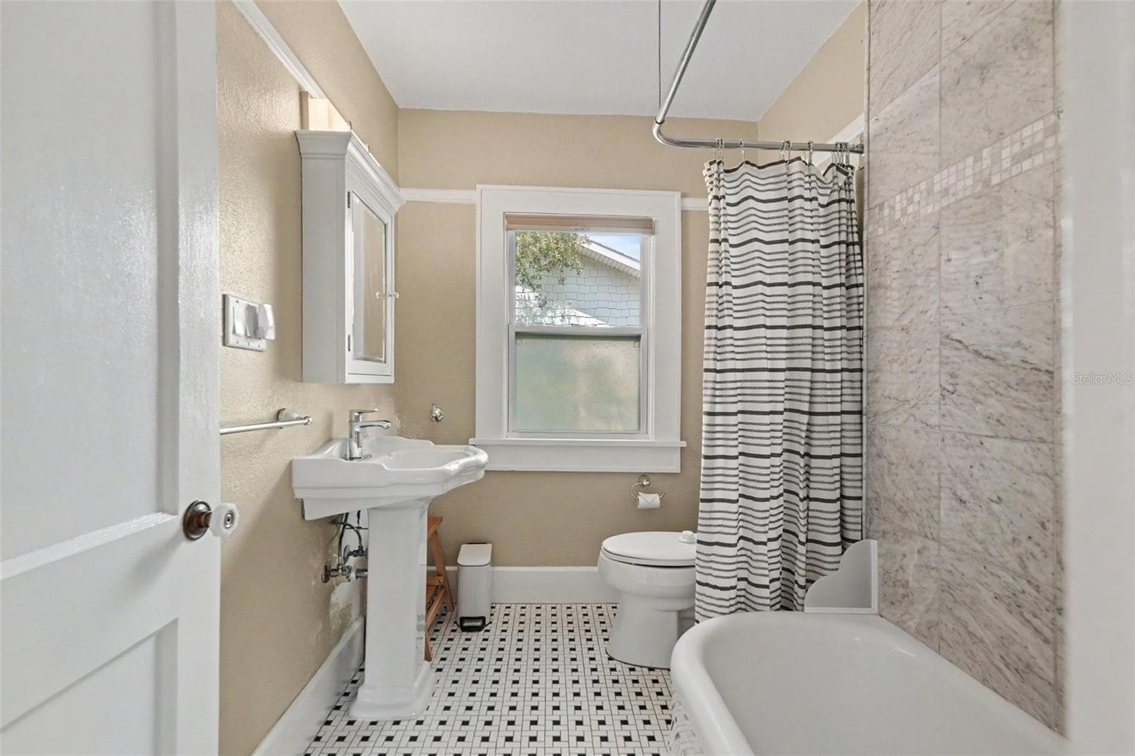 The full bathroom blends vintage character with thoughtful updates, including classic tilework, a pedestal sink, and a tub/shower combination. - 857 21ST AVE N, ST PETERSBURG