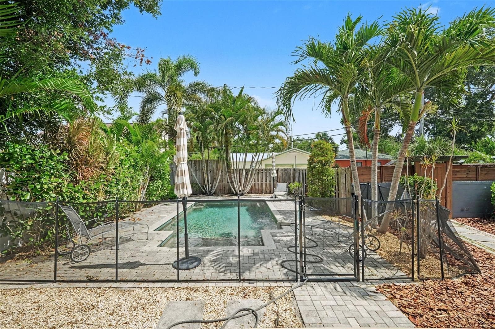 The private backyard pool is surrounded by mature tropical landscaping, creating a lush setting for relaxing and entertaining. - 857 21ST AVE N, ST PETERSBURG