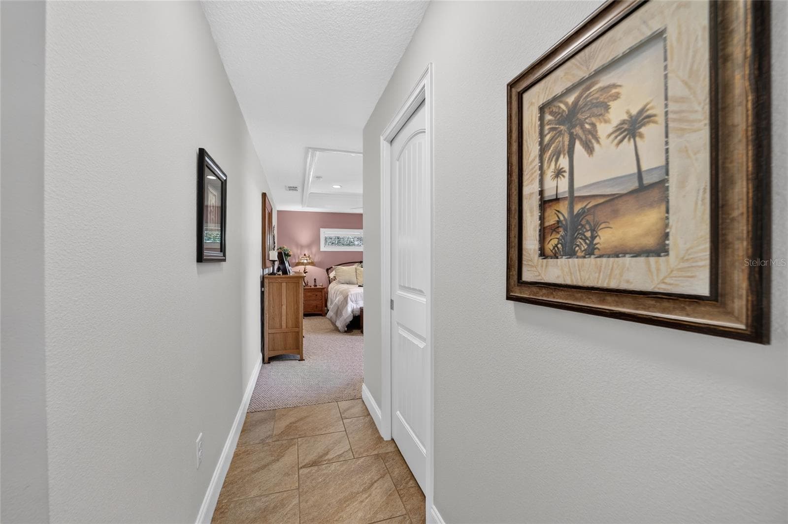 Hallway to primary bedroom with pocket-door to closet on right - 16364 SE 89TH TER, SUMMERFIELD
