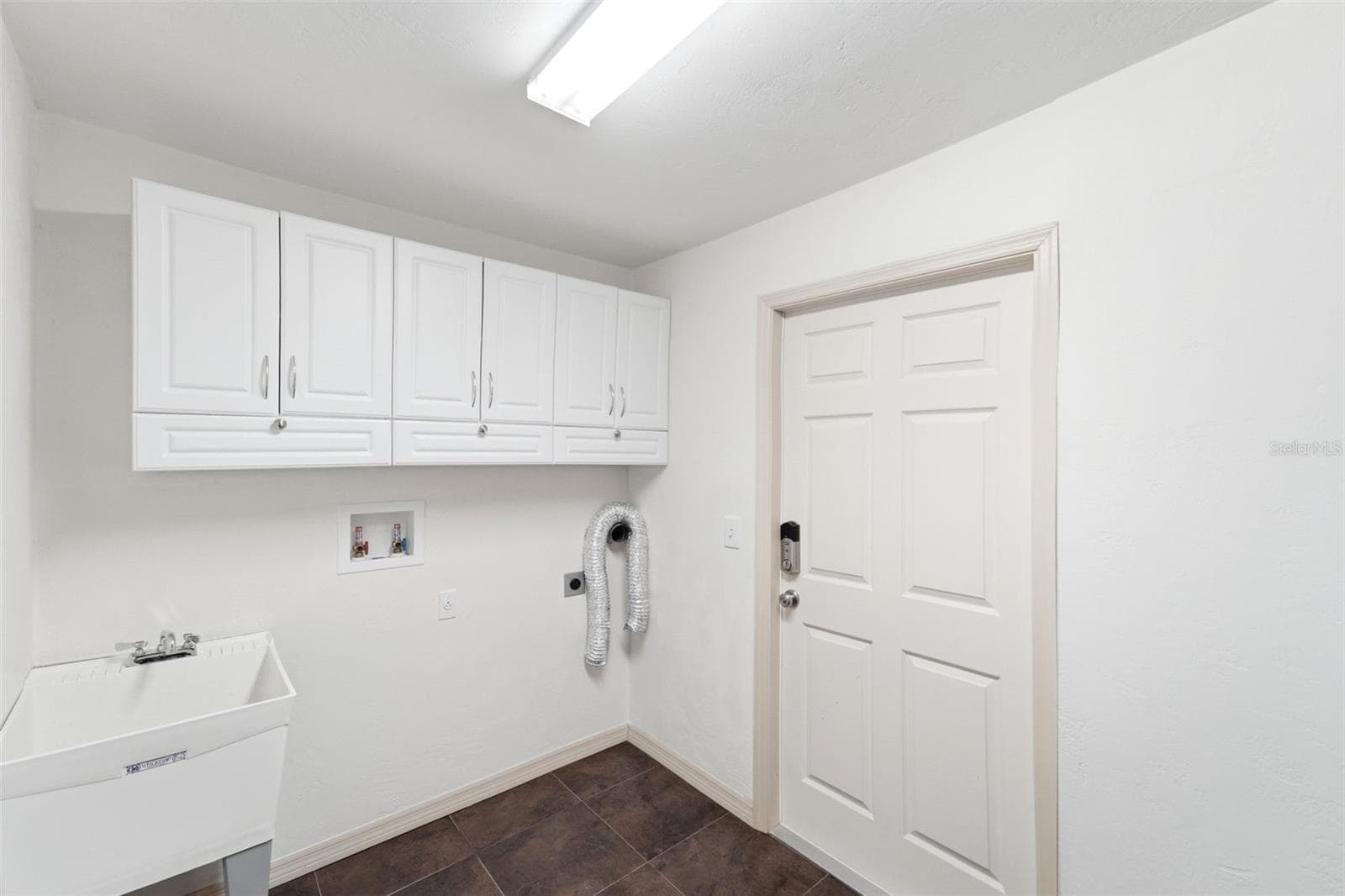 Functional laundry room with additional cabinetry for extra storage. - 59 CRESTWOOD CIR, ORMOND BEACH