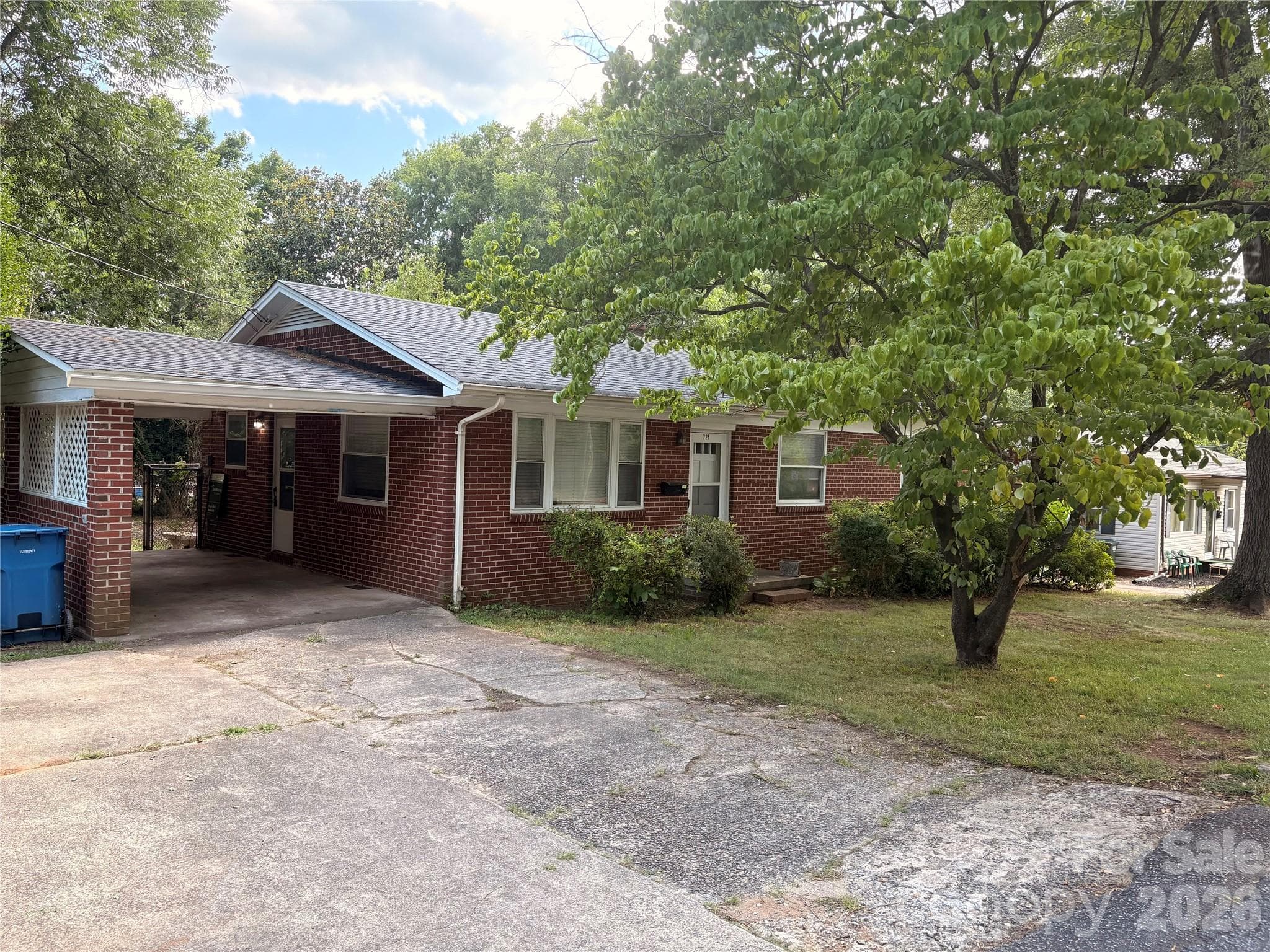 Brick exterior, one-car attached carport, and additional parking pad. - 725 5th Avenue SW, Hickory