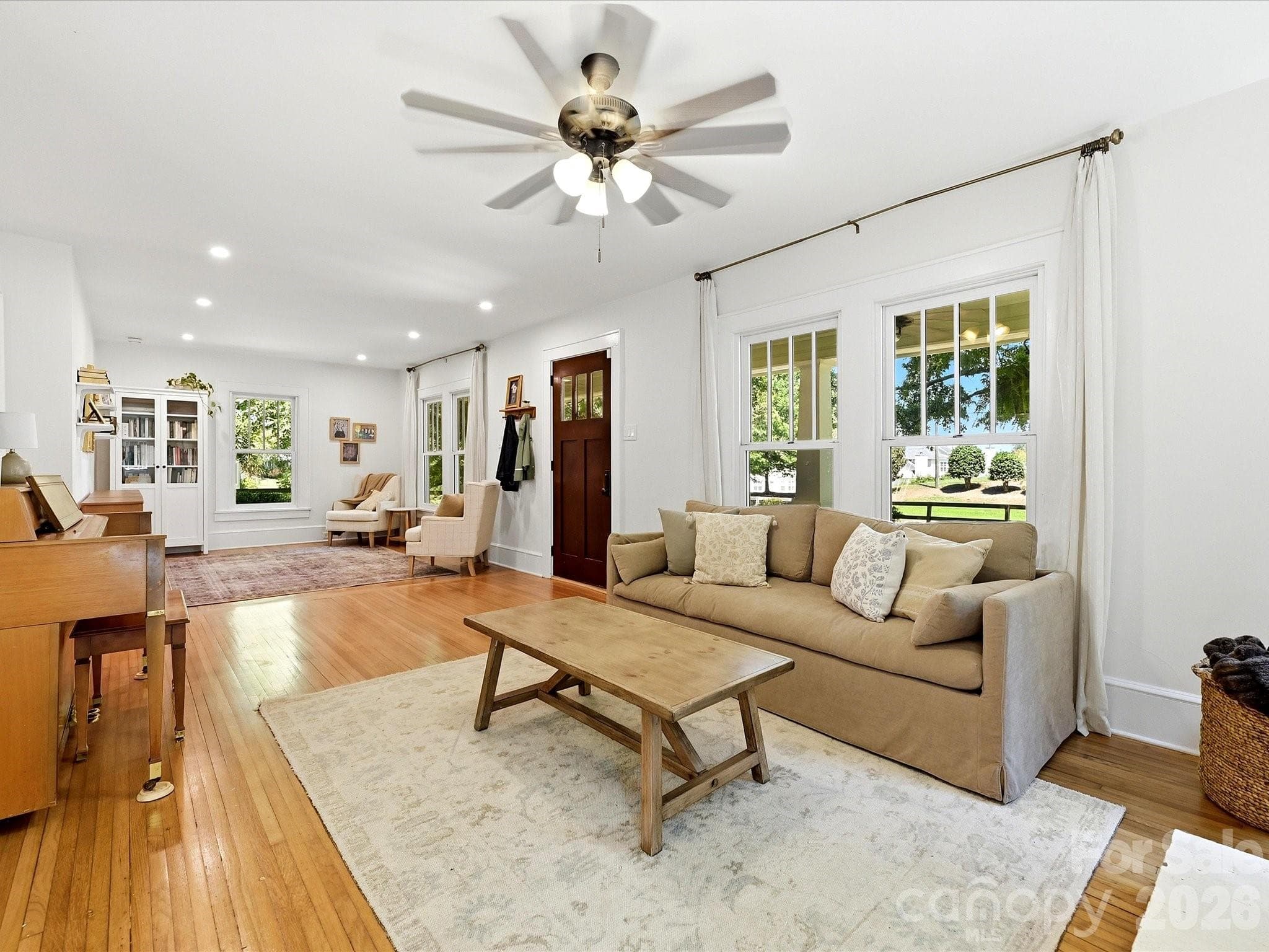 Bright and inviting living spaces feature classic hardwood floors, oversized windows, and a cozy fireplace that serves as the heart of the home. - 3514 Kelly Road, Charlotte