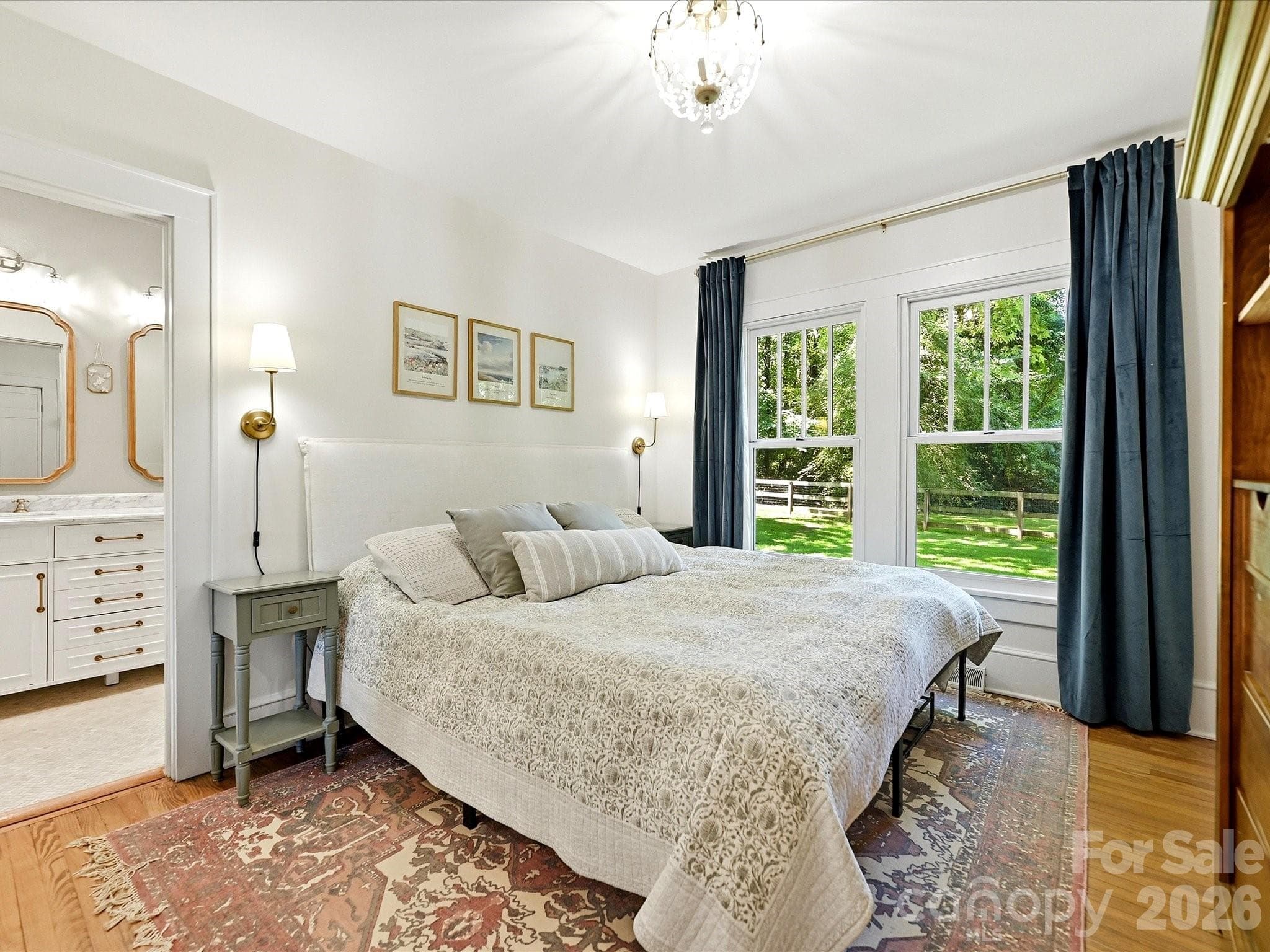 The serene primary suite offers generous natural light, hardwood floors, and direct access to a beautifully updated en-suite bathroom. - 3514 Kelly Road, Charlotte