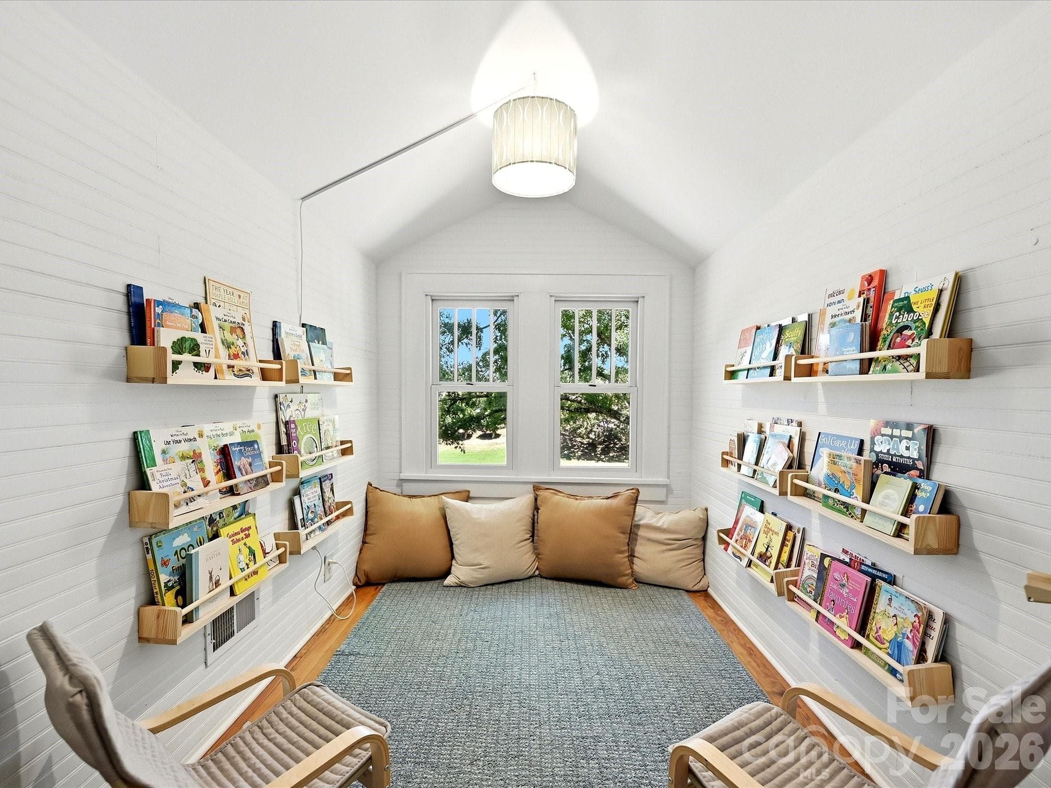 The charming upstairs reading nook/loft offers vaulted ceilings, built-in book displays, and a cozy retreat perfect for relaxing with your favorite book. - 3514 Kelly Road, Charlotte