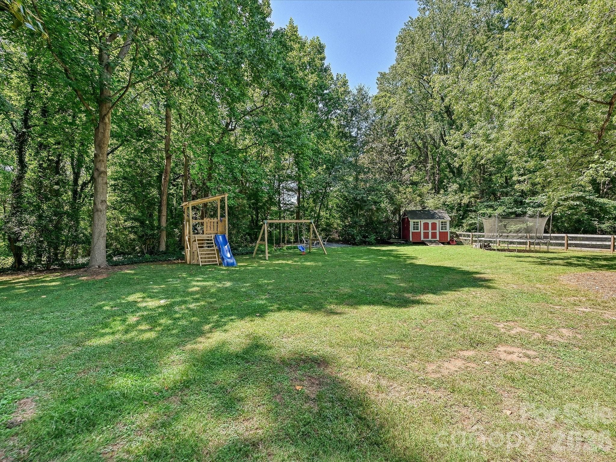 The large, level backyard offers endless opportunities for recreation, gardening, and outdoor enjoyment, surrounded by mature trees for added privacy. - 3514 Kelly Road, Charlotte