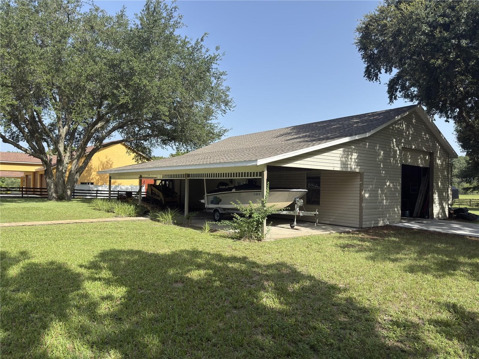 The garage has a RV-sized roll-up door on either end. - 32137 WOLF BRANCH LN, SORRENTO