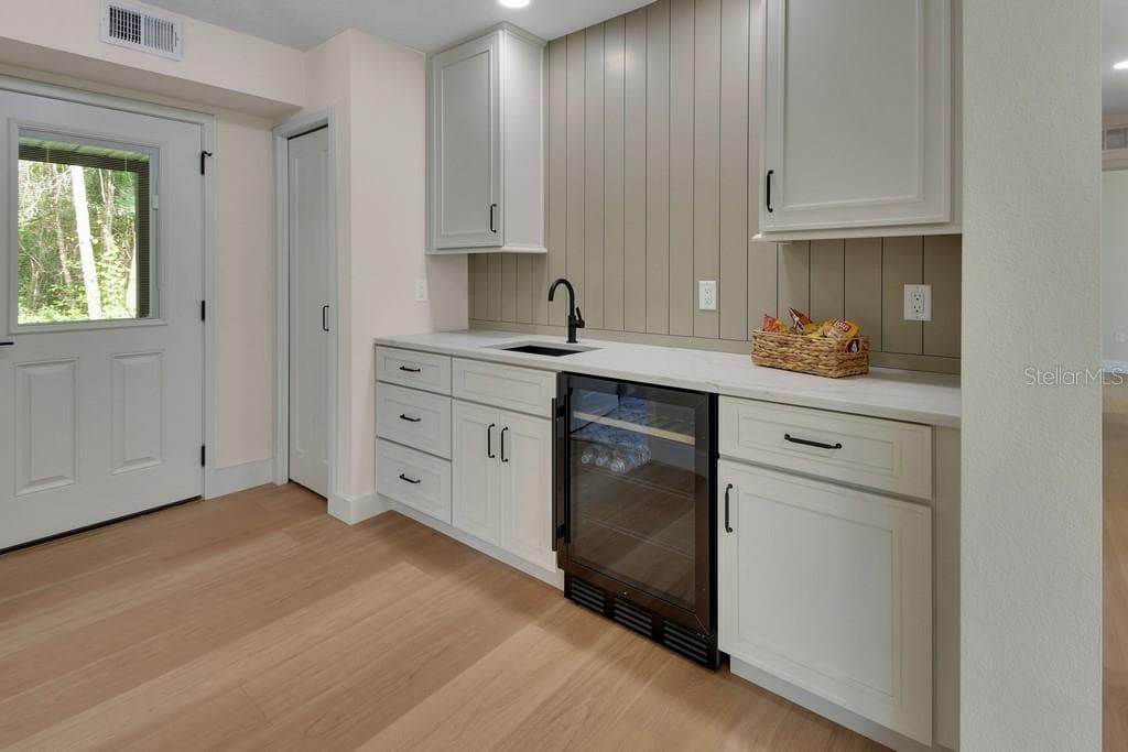 Mini fridge/wine cooler.Beautiful cabinetry. Coat closet to the left. - 1530 DEERMOSS LN, DELAND