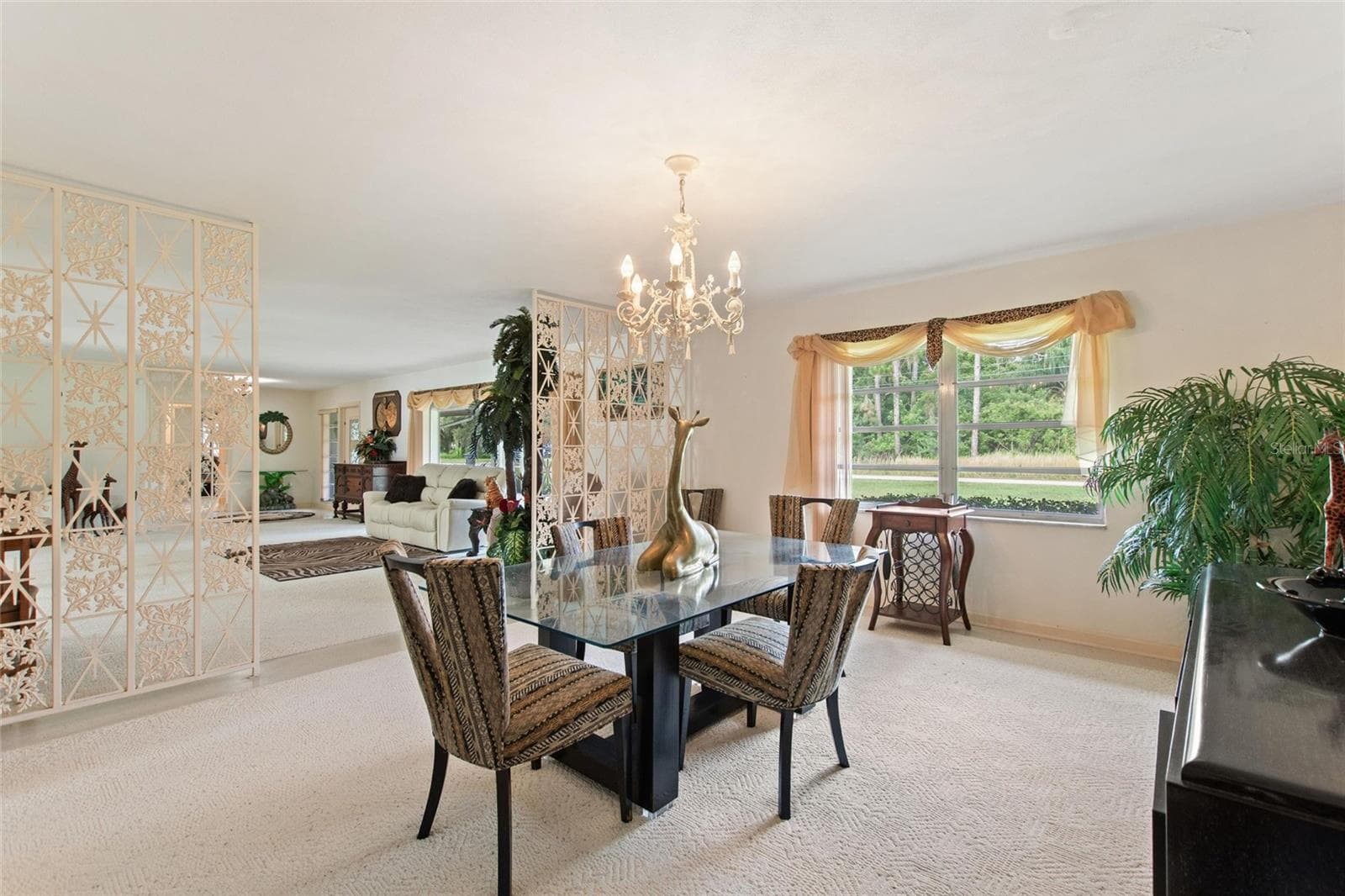 Reverse view of dining room looking back into the living room. Don't you just love those wrought iron room dividers! - 6197 AMARYLLIS DR, INDIAN LAKE ESTATES